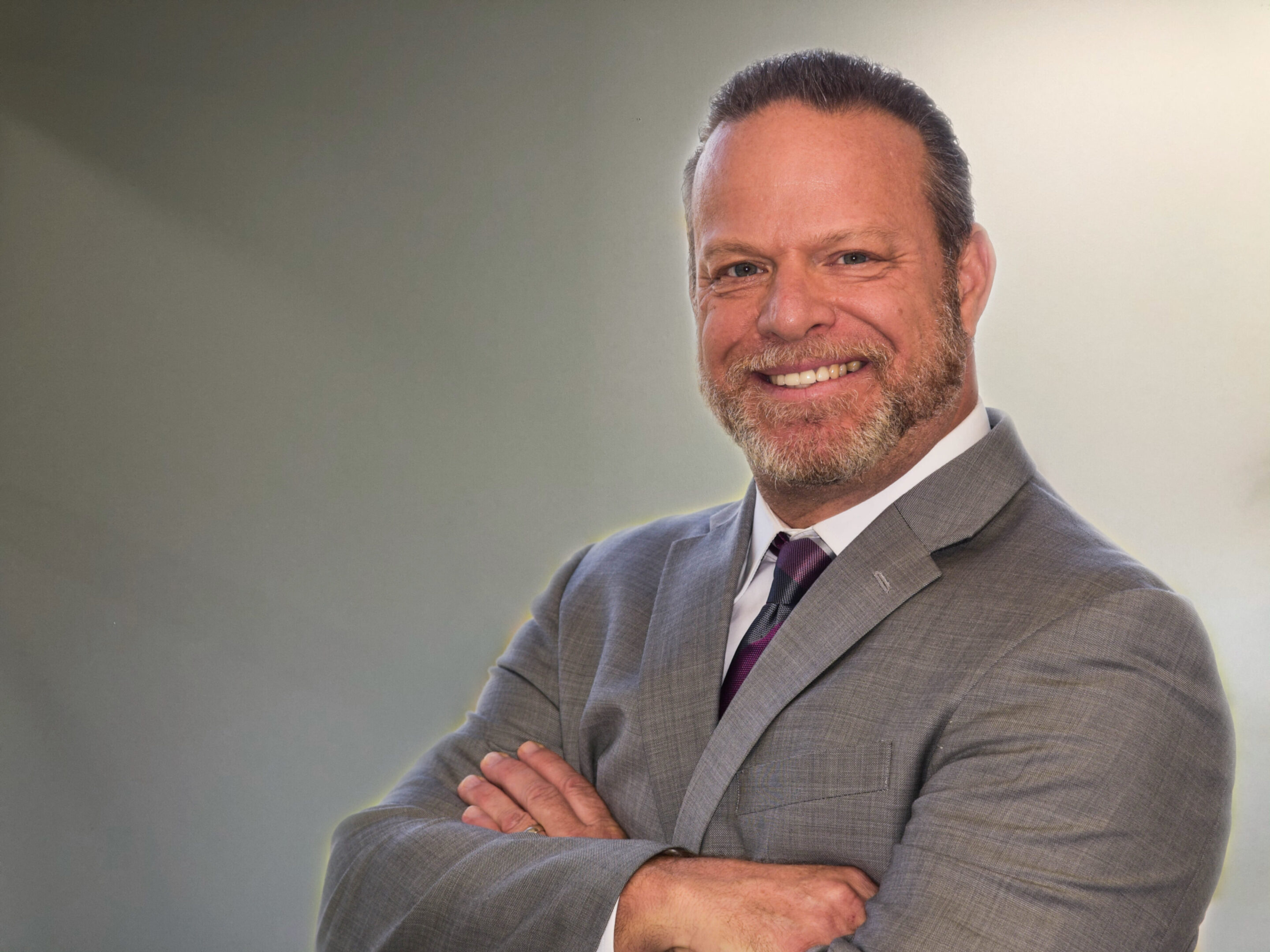 A man in a suit and tie with his arms crossed.