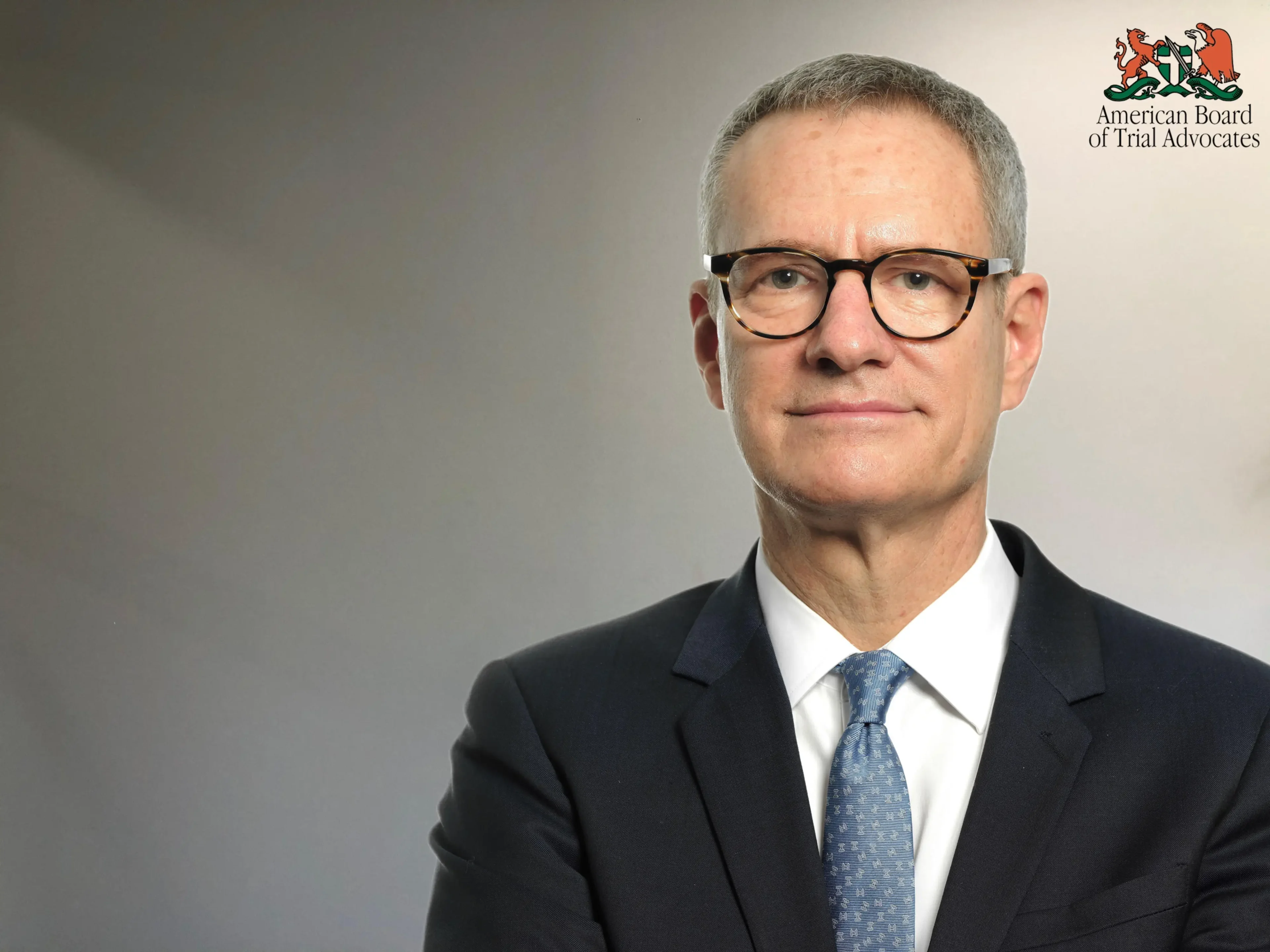 A man in suit and tie wearing glasses.