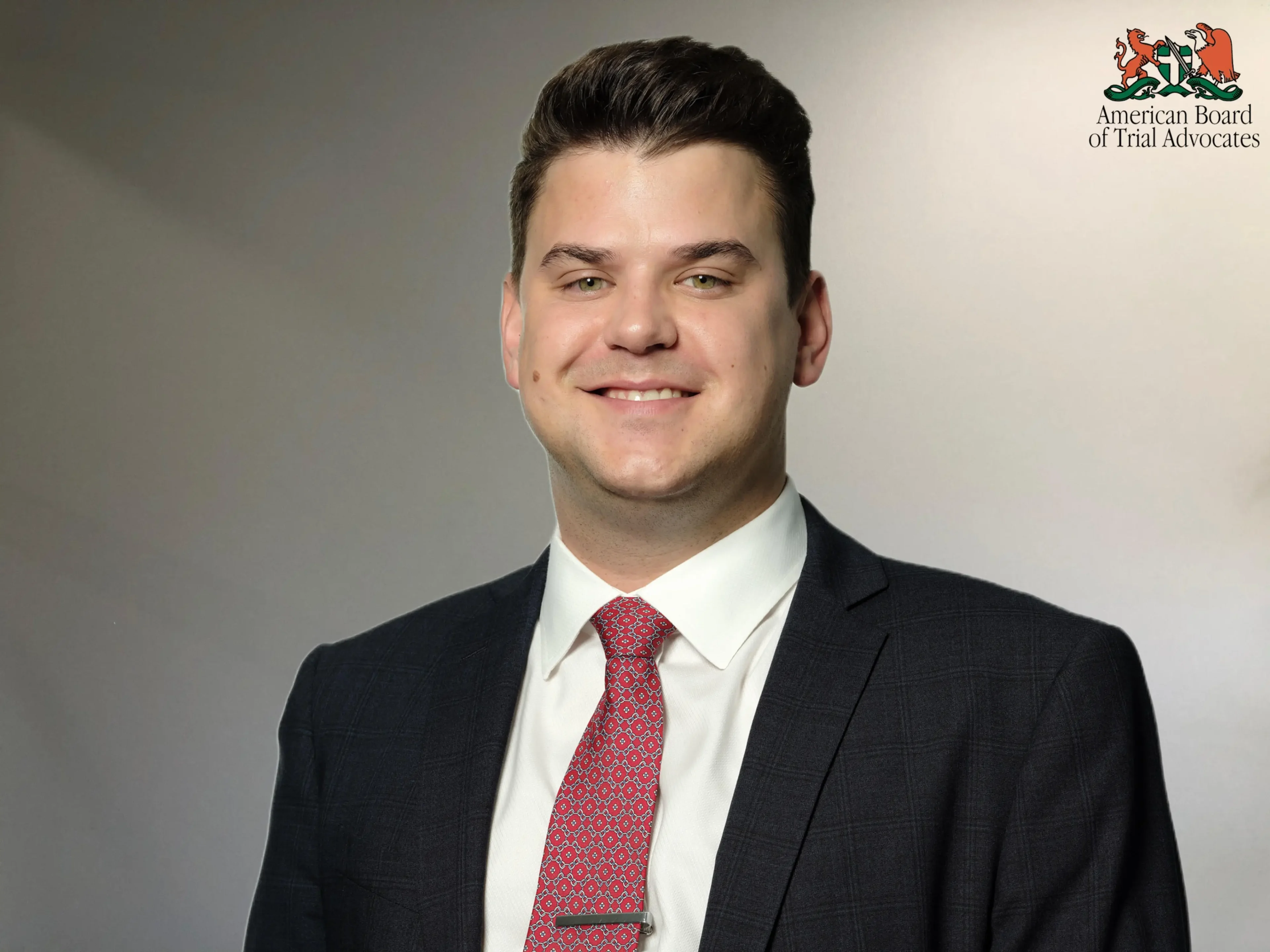 A man in suit and tie smiling for the camera.