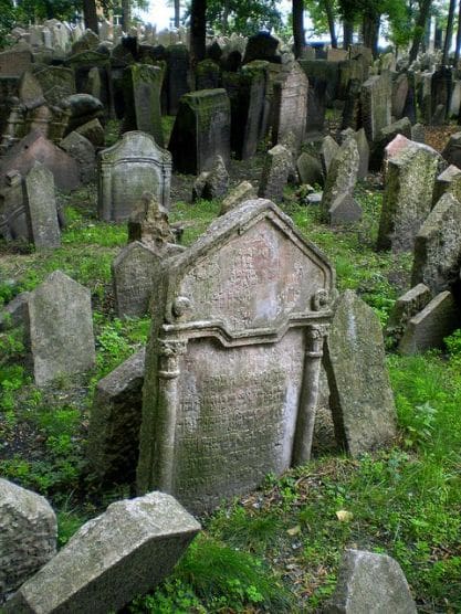 A cemetery with many old tombstones and grass.