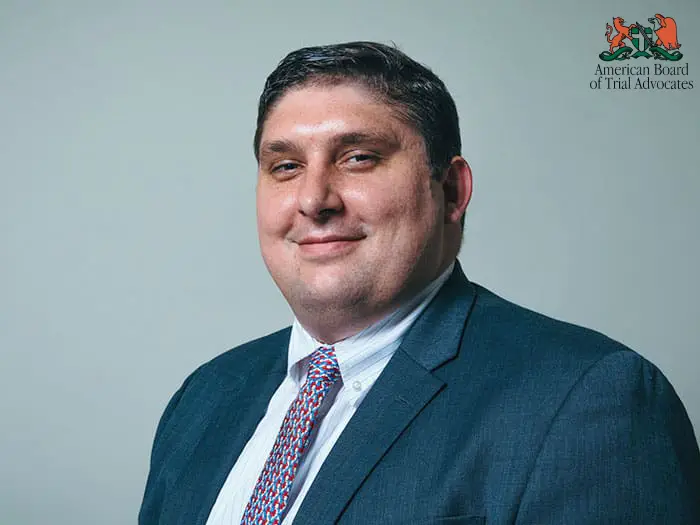 A man in a suit and tie standing next to a wall.