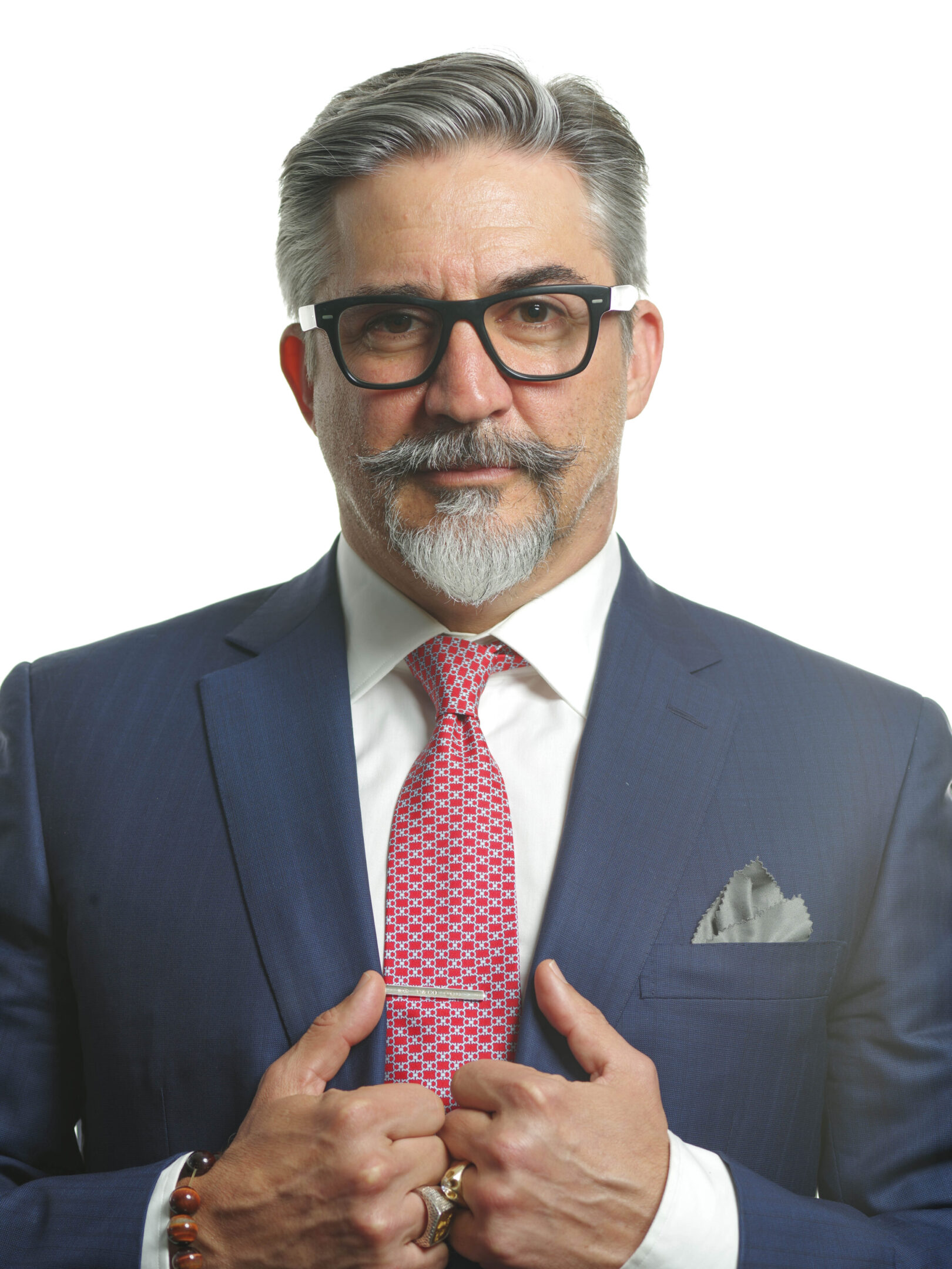 A man in a suit and tie holding his hands together.