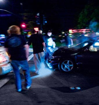 A group of people standing around an accident.