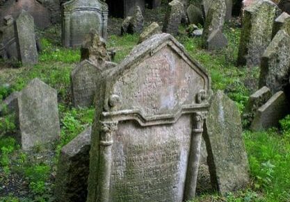 A cemetery with many old tombstones and grass.