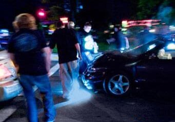 A group of people standing around an accident.